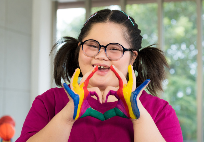 Girl With Colourful Painted Hands — Disability Services in Mackay, QLD