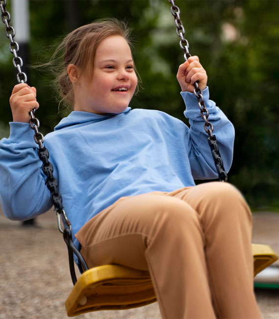 Happy Child with Down Syndrome Playing Outside — Point Care Pty Ltd in Gladstone, QLD