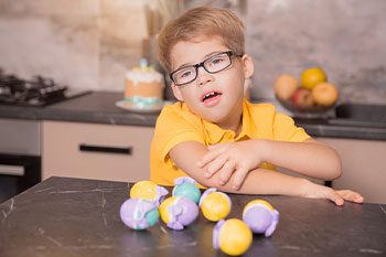 Boy With Down Syndrome Playing With Balls — Disability Services & Support in Caboolture, QLD