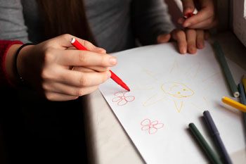 Carer Teaching Child How To Draw And Write — Disability Services & Support in Loganholme, QLD