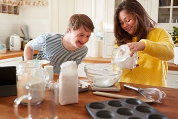 Carer Teaching Man With Down Syndrome How To Bake — Disability Services & Support in Maroochydore, QLD