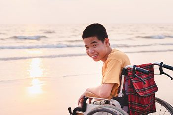 Child On A Wheelchair In Sea — Disability Services & Support in Gympie, QLD