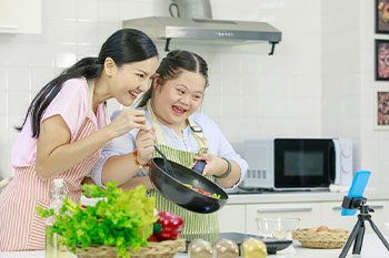 Cooking In The Kitchen With Apron — Disability Services & Support in Loganholme, QLD