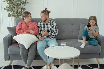 Couple Sitting On A Couch With Their Child