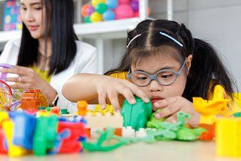 Down Syndrome Playing With Blocks — Disability Services & Support in Caboolture, QLD