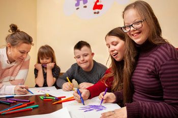 Happy Girl with Down Syndrome Posing While Drawing — Point Care Pty Ltd in Gladstone, QLD