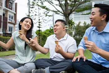 Man With Down Syndrome Eating Ice Cream With Friends — Disability Services & Support in Brisbane, QLD