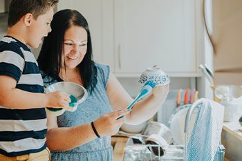 Mother Teaching Son How To Do Dishes — Disability Services & Support in Nambour, QLD