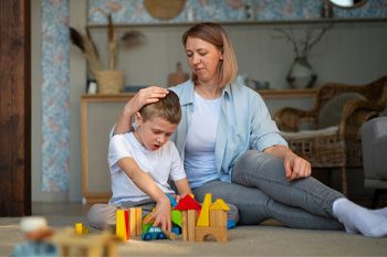 Mother Playing with Her Autistic Son Using Toys — Point Care Pty Ltd in Gladstone, Qld