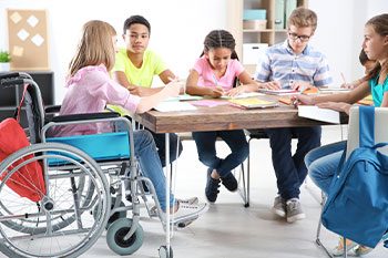 Teenage Girl In A Wheelchair With Other Students Studying — Disability Services & Support in Brisbane, QLD
