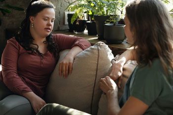 Woman Talking With A Girl Who Has Down Syndrome — Disability Services & Support in Maroochydore, QLD