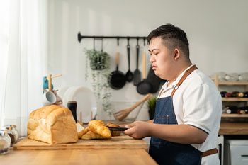 Young Man With Down Syndrome Baking — Disability Services & Support in Brisbane, QLD