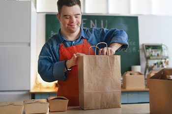 Young Man With Down Syndrome Working  — Disability Services & Support in Sunshine Coast, QLD